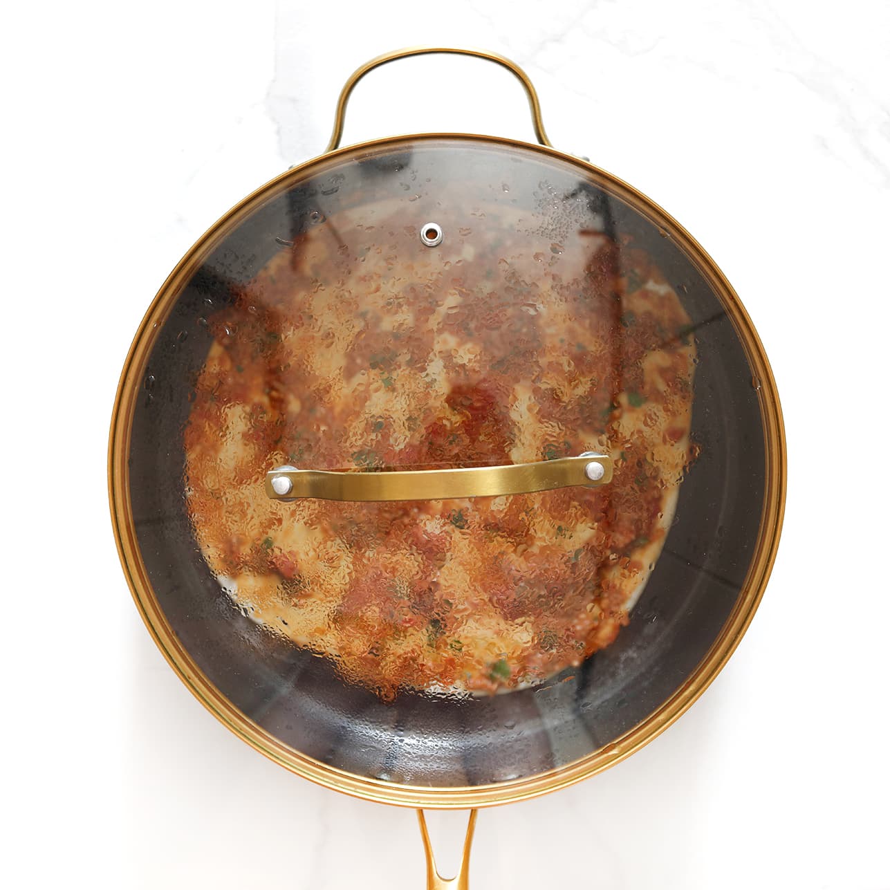 Zelfgemaakte lahmacun wordt gebakken in een pan met deksel.