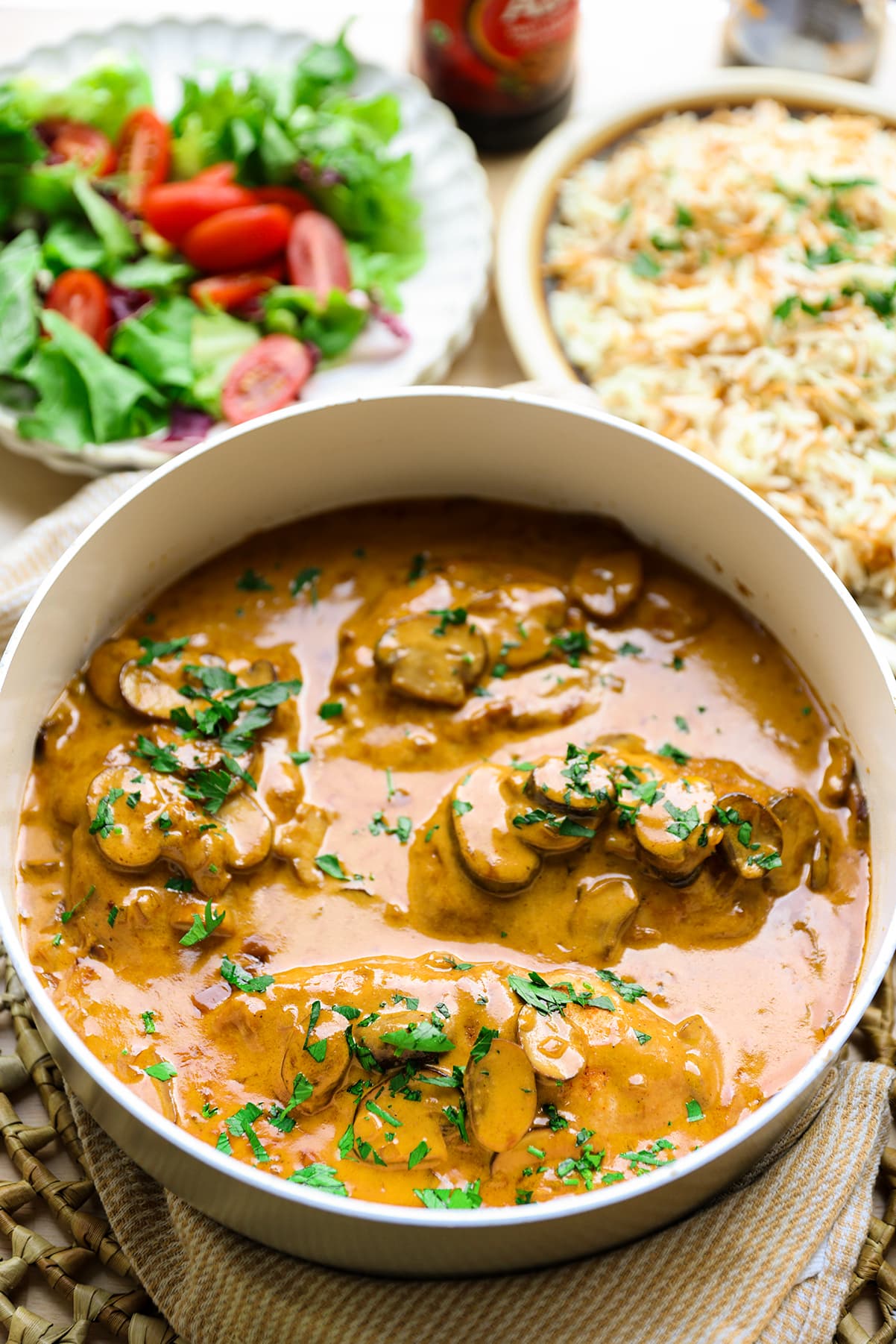 Kipfilet in romige champignonsaus geserveerd op een bord met verse kruiden