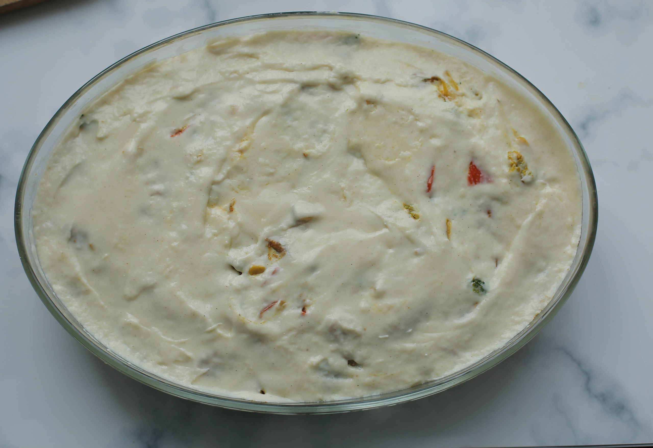 Bechamelsaus toevoegen aan de aardappelpuree en kipmengsel