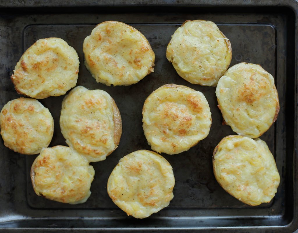 Leg de aardappels in een voorverwarmde oven op 220℃ en bak 10-15 minuten of tot de kaas is gesmolten.