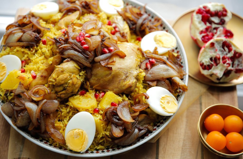 Verdeel de kip met rijst op een groot bord. Schep de gekarameliseerde ui erop en garneer met ei.