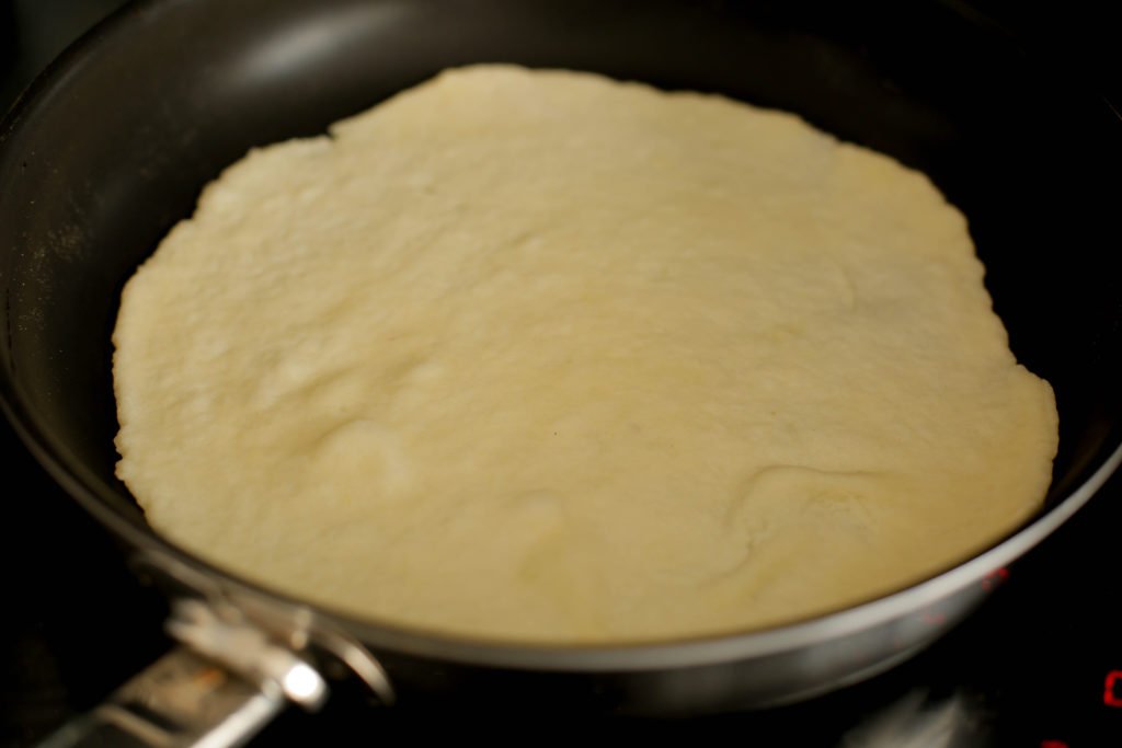 Vet een pan met dikke bodem goed in met zonnebloemolie. Bak het naanbrood aan beide kanten gaar. Herhaal de werkwijze.