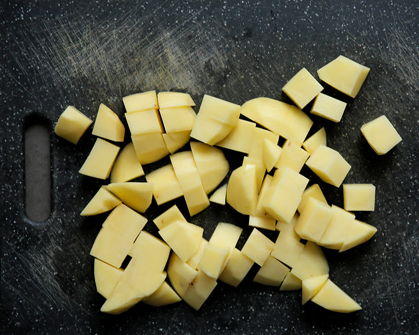 Schil de aardappels en snijd deze in blokjes.