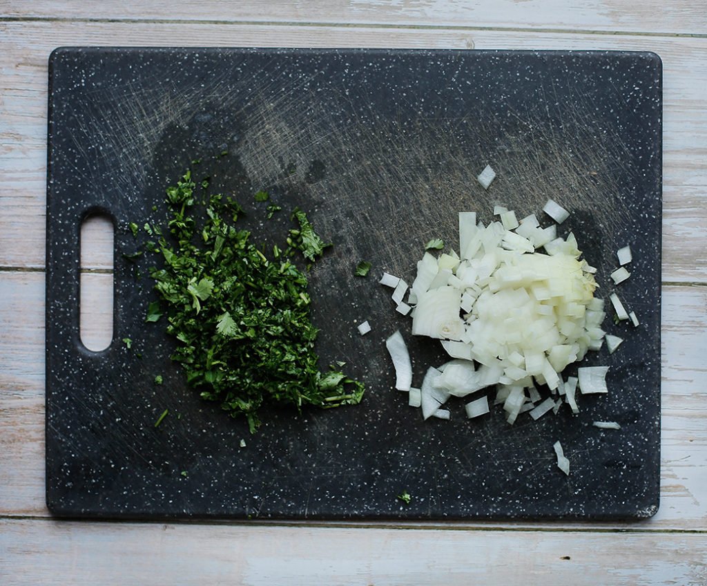 Pel en snipper de gele ui (125 gr). Hak de koriander fijn.