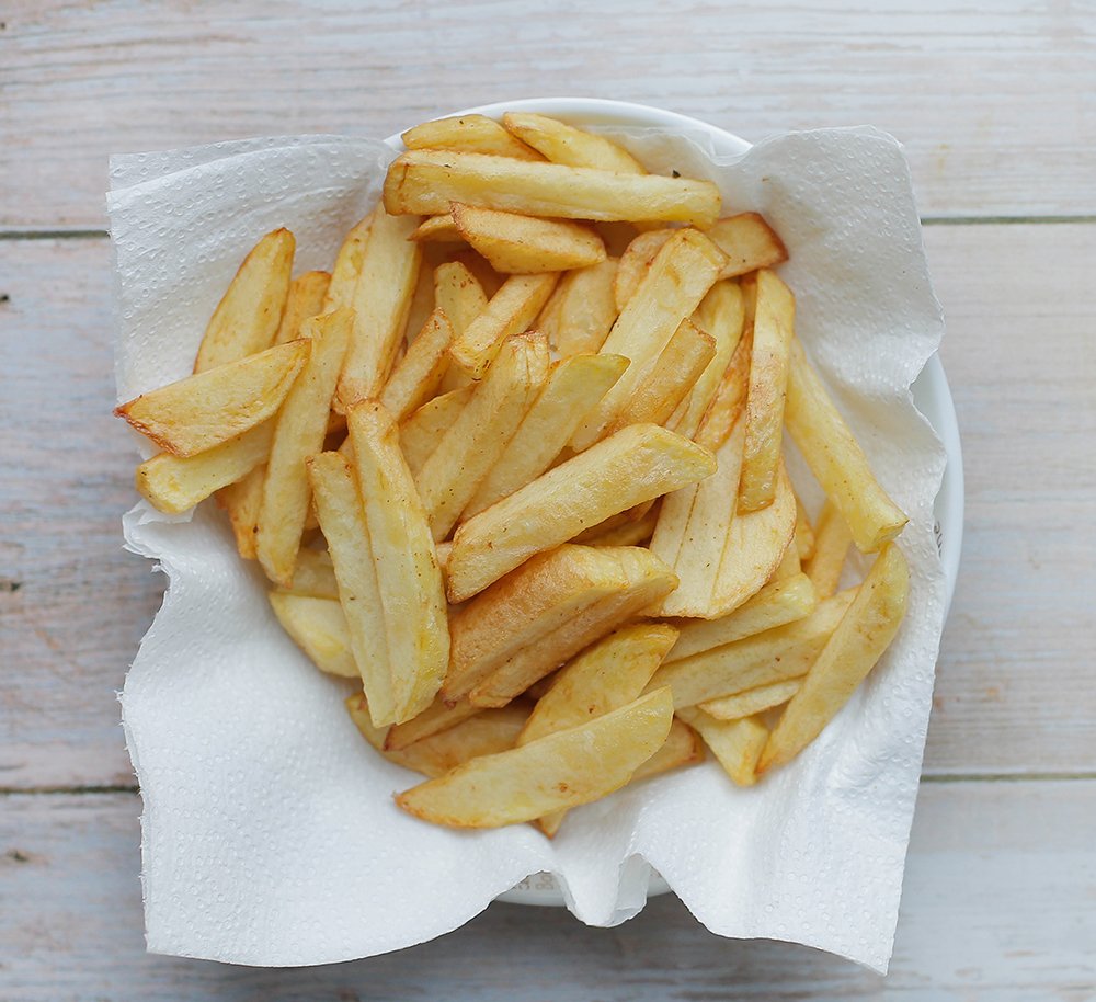 Bak de friet in een paar minuten mooi goudbruin. Schep de friet uit de pan en laat uitlekken op keukenpapier. Leg apart.