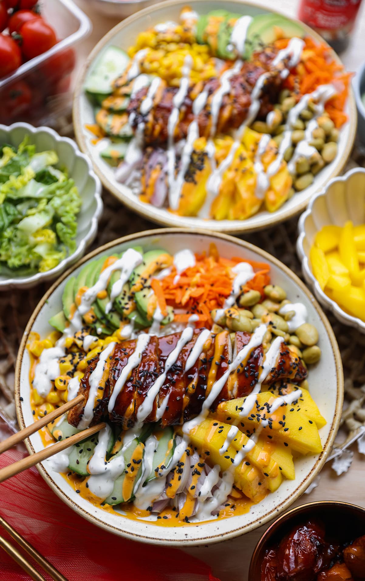 Poke bowl met gegrilde kip, rijst, avocado, wortel en komkommer in een kom van bovenaf