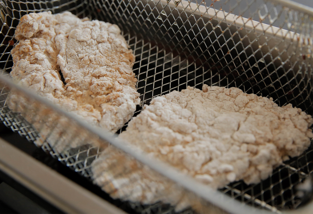 Verhit een laagje zonnebloemolie in een koekenpan (175 ℃). Bak elke kant van de kip in ca. 3 minuten gaar. In de friteuse bak je de kip in ca. 3-4 minuten gaar.