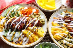 Poke bowl met kip, rijst, avocado, komkommer en verse groenten in een kleurrijke kom