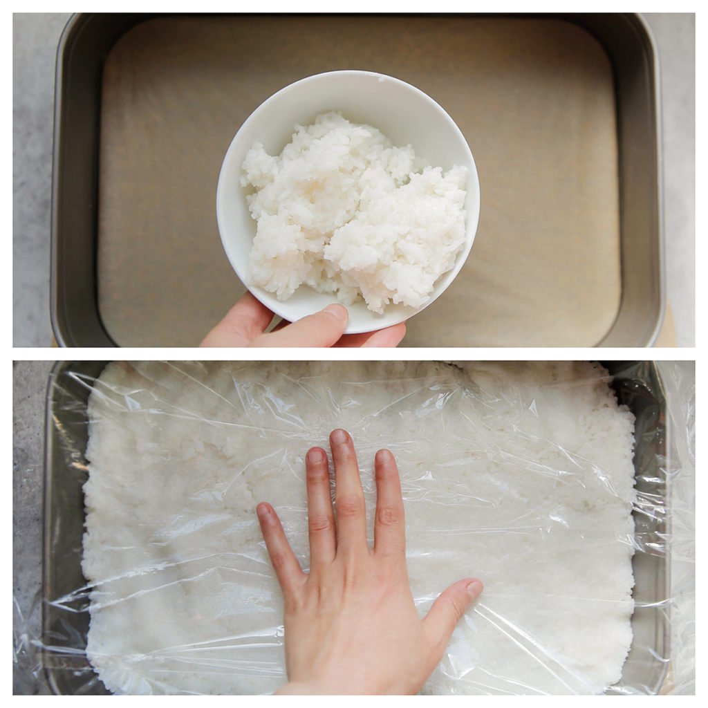 Bedek de bakvorm met een vel bakpapier. Schep de helft van de rijst erop. Druk alles stevig aan met huishoudfolie of maak je handen nat en druk het iets aan.