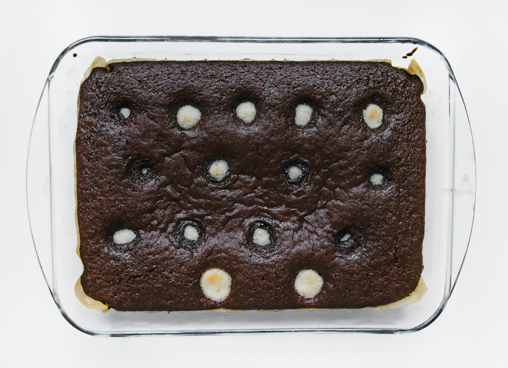 Zet de chocoladecake met kokosbollen in een voorverwarmde oven op 170 ℃. Bak 25-30 minuten. De cake is gaar wanneer je er met een satéprikker in prikt en er droog uitkomt. Laat de cake op kamertemperatuur komen.