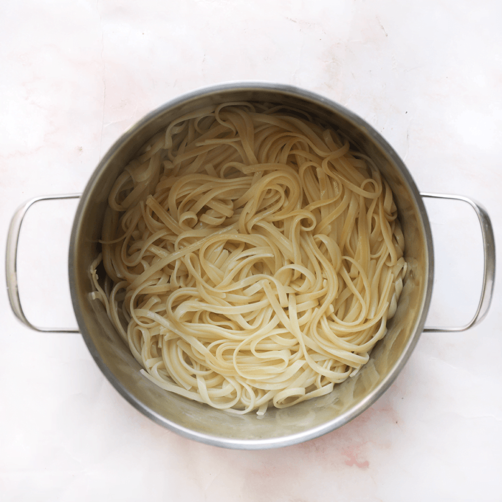 Breng een pan met water aan de kook. Voeg het zout en de linguine toe. Meng goed. Kook 11-13 minuten. Schep 150 ml van het pastawater voorzichtig uit de pan en leg dit apart. Laat het overige water uitlekken.
