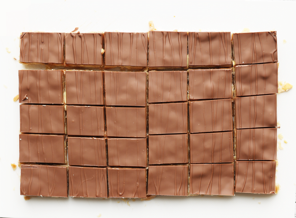 Wanneer de pinda-chocoladekoek goed stevig is, snijd je deze in mooie blokjes met een warm, scherp mes.