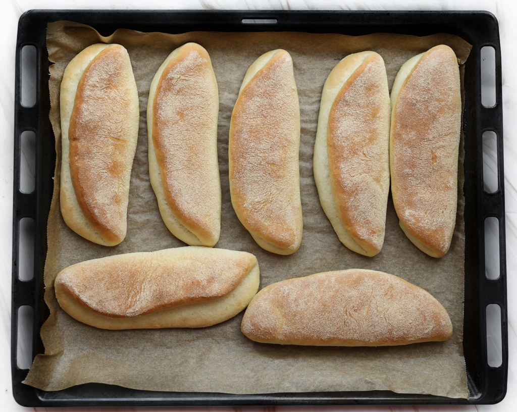 Zet de broodjes in een voorverwarmde oven op 200℃. Bak ze 10-15 minuten, of totdat de broodjes mooi goudbruin zijn gekleurd. Houd de baktijd zelf in de gaten, want elke oven werkt anders. Dek de broodjes direct af met een theedoek, zo worden ze lekker zacht.