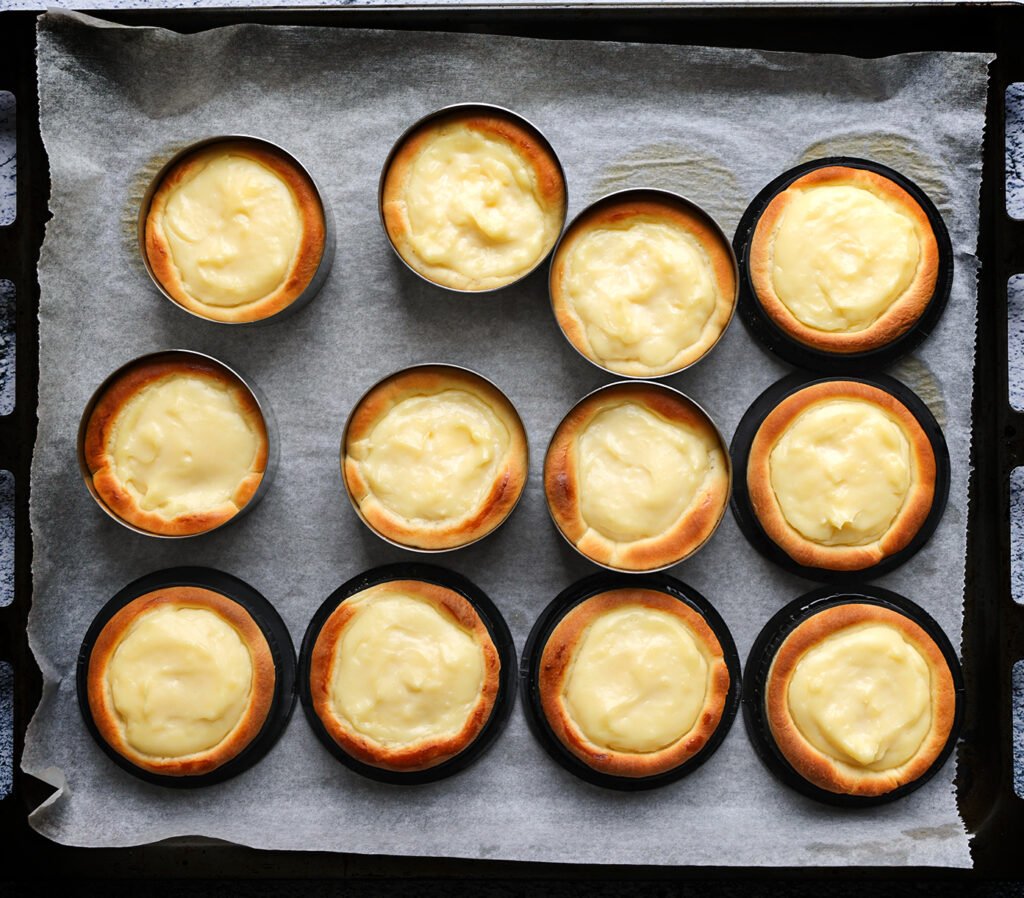 Zet de gele room taartjes in een voorverwarmde oven op 200 °C. Bak 10-12 minuten of tot ze mooi goudbruin zijn. Houd de baktijd goed in de gaten, omdat elke oven anders kan werken. Laat de taartjes afkoelen.