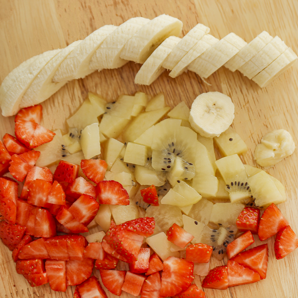 Snijd de aardbeien en kiwi in stukken en de banaan in plakjes.