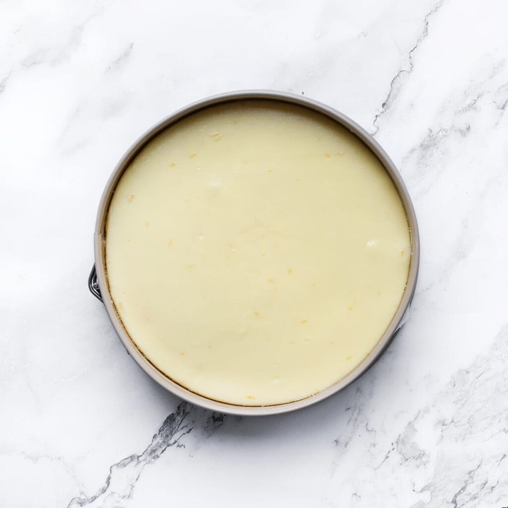 Zet de lemon cheesecake in een voorverwarmde oven op 125 ℃. Bak 60-65 minuten of tot de zijkanten stevig zijn en het midden nog een beetje wiebelt. Schakel de oven uit en laat de lemon cheesecake 1 uur in de oven liggen. Dit voorkomt dat de cheesecake inzakt/scheurt.