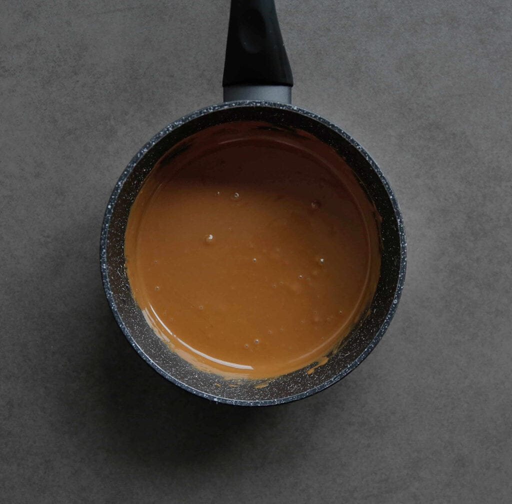 Verwarm 100 gram speculoospasta al roerend in een steelpan op laag vuur totdat het vloeibaar is. Blijf erbij staan, want dit proces gaat snel. Laat het iets afkoelen.