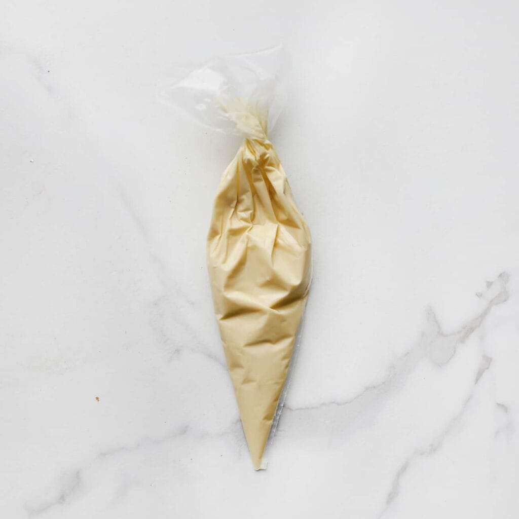 Doe de witte chocolade in een spuitzak.