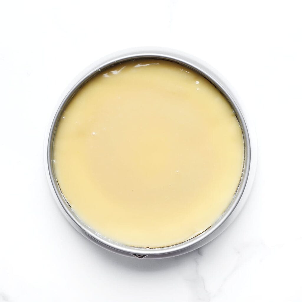 Giet de ganache over de cheesecake en laat deze enkele uren opstijven in de koelkast, bij voorkeur een hele nacht.