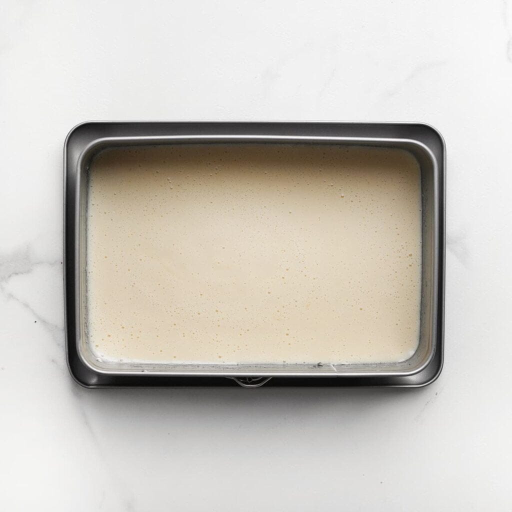 Giet het beslag in een ingevette springvorm en bekleed de bodem met bakpapier. Bak de cake in een voorverwarmde oven op 160 ℃ voor 12-18 minuten, of totdat de cake gaar is (de cake is gaar wanneer een sat&eacute;prikker er droog uitkomt). Let goed op de baktijd, want elke oven is anders. Laat de cake 10-15 minuten afkoelen.