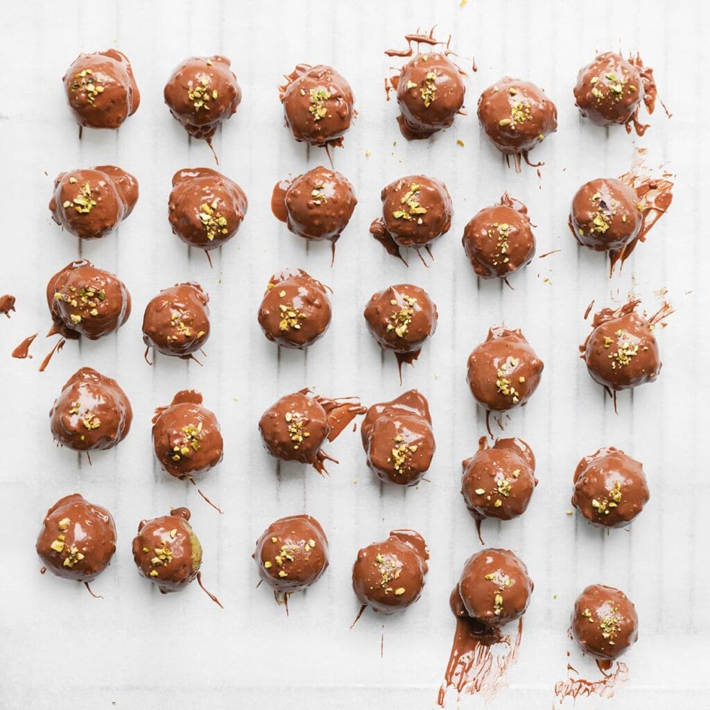 Garneer de pistachetruffels met wat gehakte pistachenoten en laat ze uitharden.