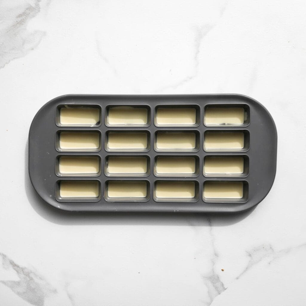 Vul een siliconenvorm met een dun laagje gesmolten chocolade en zet deze 30-45 minuten in de koelkast, of totdat de chocolade volledig is uitgehard.