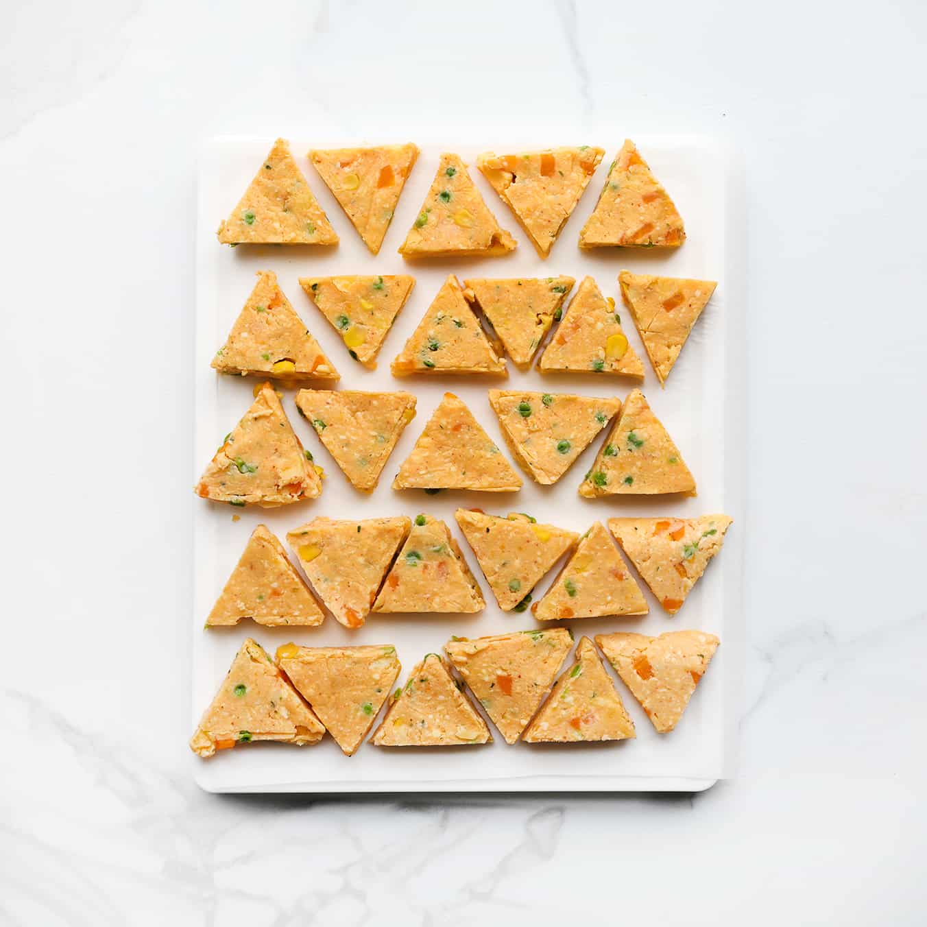 Kaasdriehoekjes op een vel bakpapier leggen