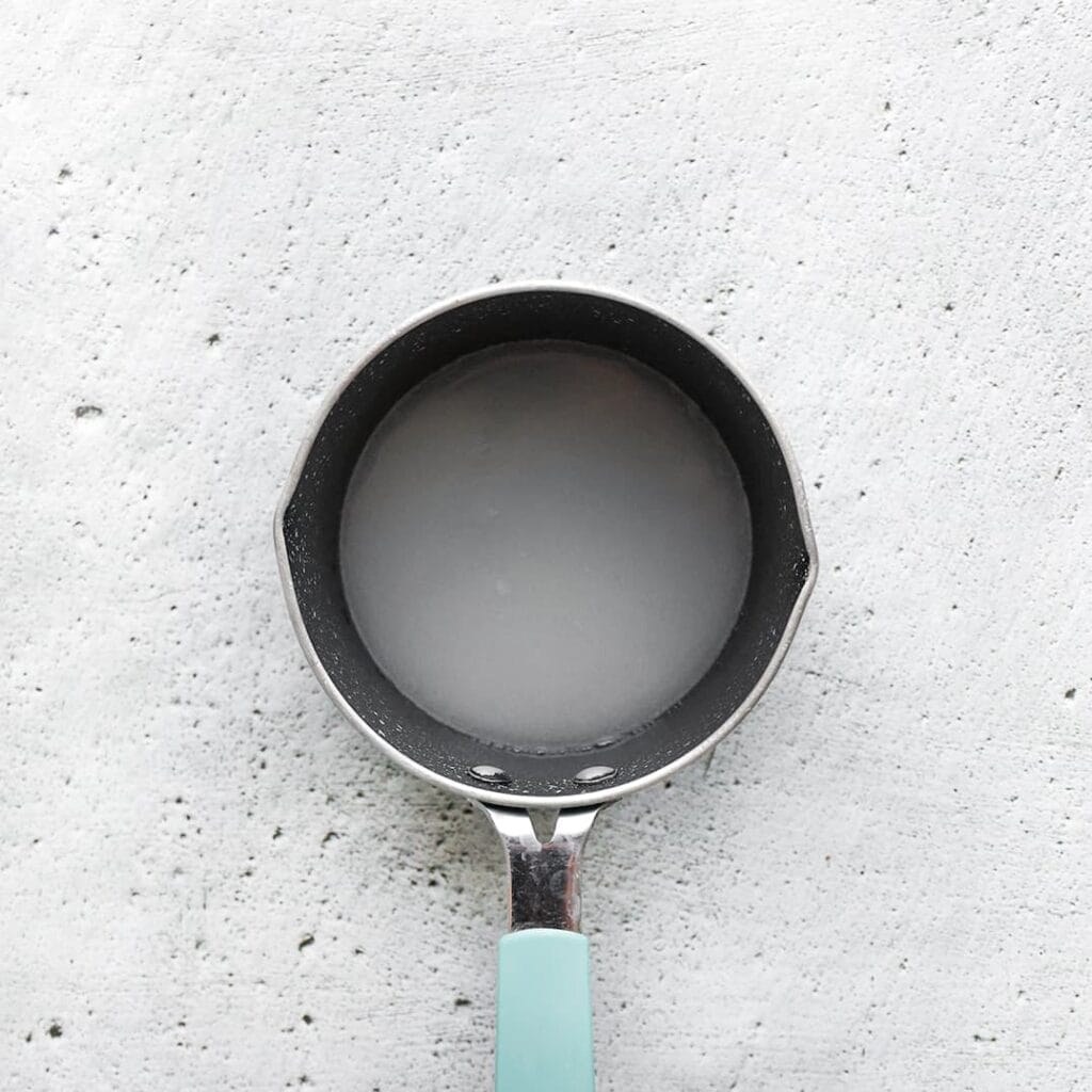 Doe het water en de suiker in een steelpan en zet het op middelhoog vuur. Roer voorzichtig totdat de suiker volledig is opgelost. Dit duurt meestal een paar minuten. Zorg ervoor dat je een pan gebruikt met een dikke bodem, zodat de warmte gelijkmatig wordt verdeeld.