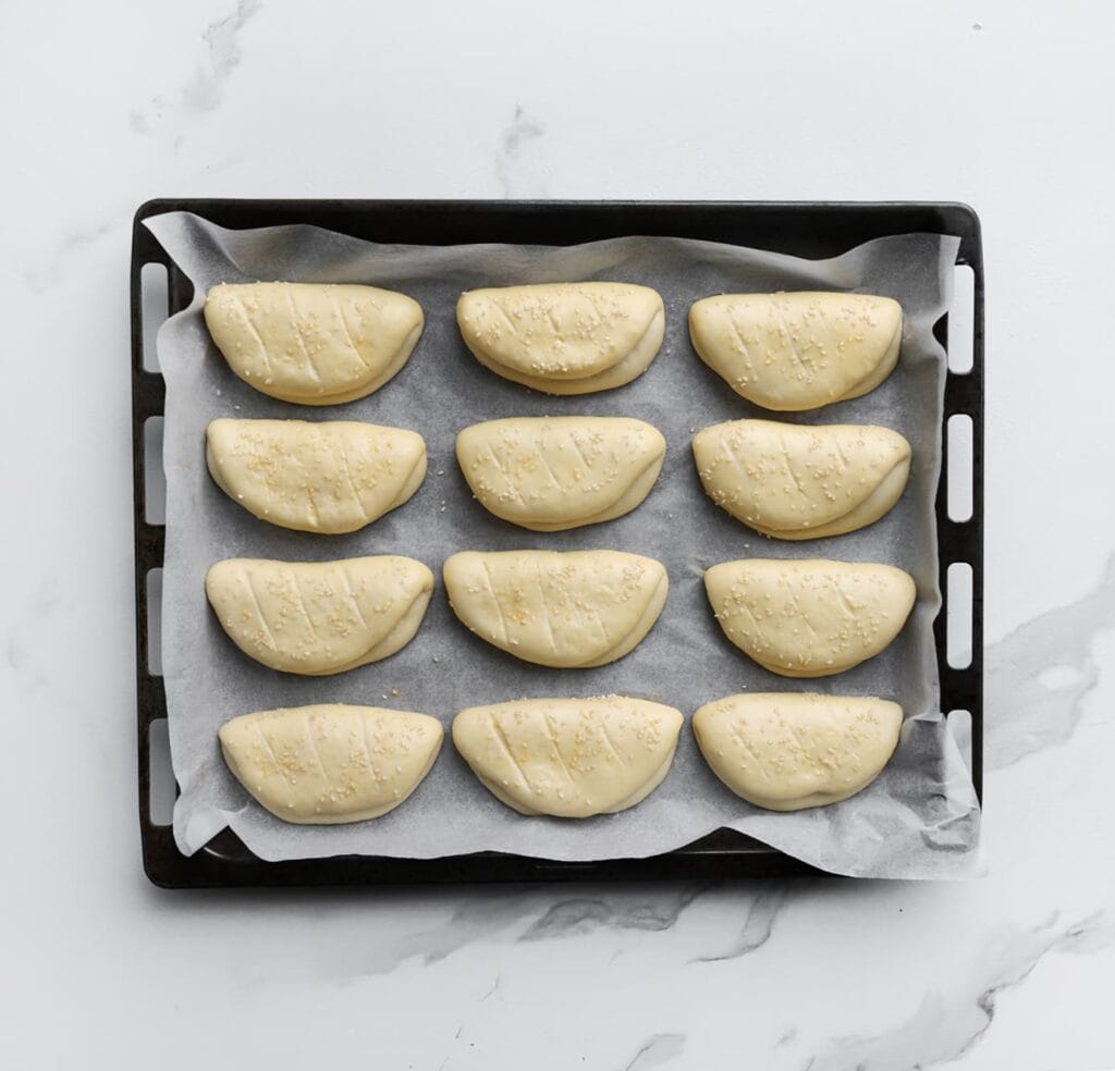 Laat het deeg 30 minuten rijzen op een warme plek, of totdat de stukken in formaat zijn verdubbeld.