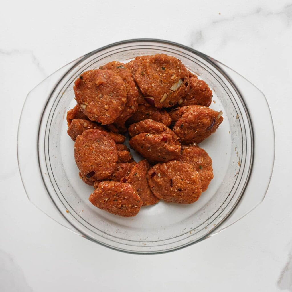 Neem een portie van het gehakt en vorm deze tot een bol. Druk de bol vervolgens iets plat.