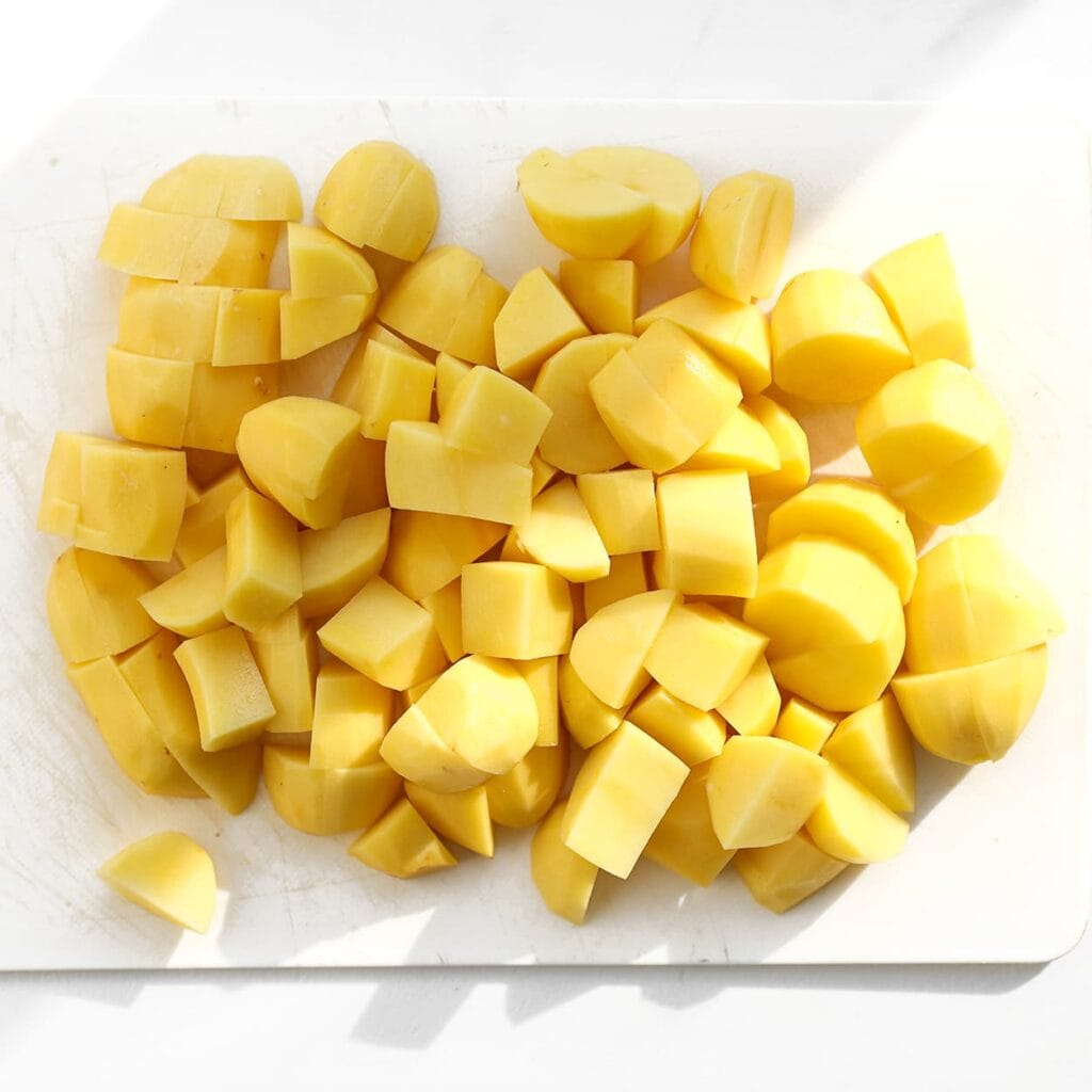 Schil de aardappels en snijd ze in stukken.