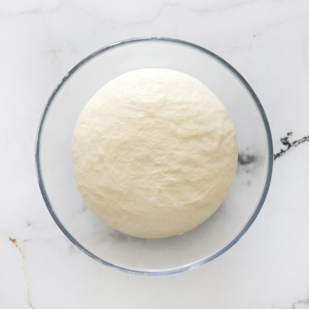 Dek de kom af en laat het deeg 1 uur rijzen op een warme plek, of tot het in omvang is verdubbeld.