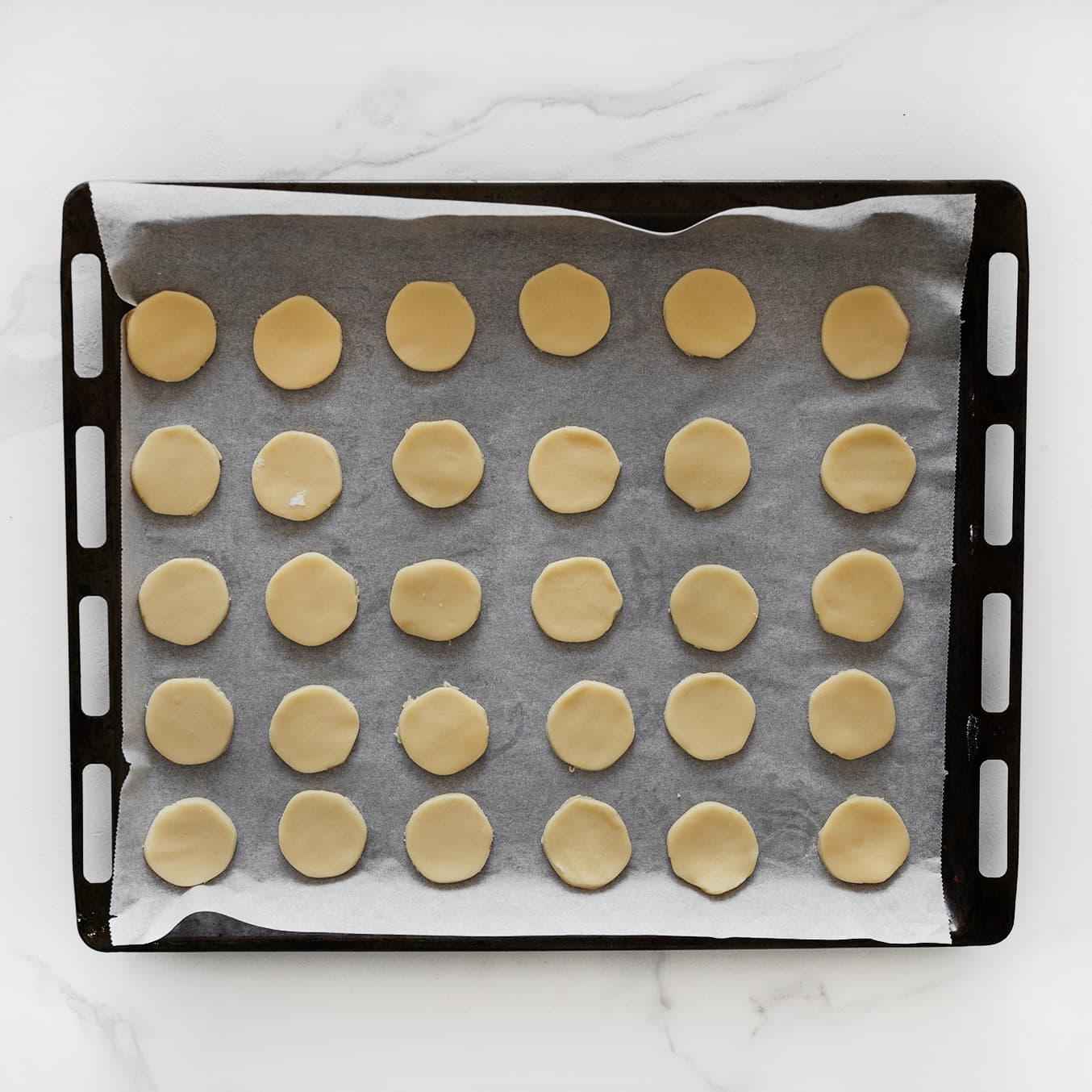 Koekjesdeeg op bakplaat met bakpapier leggen