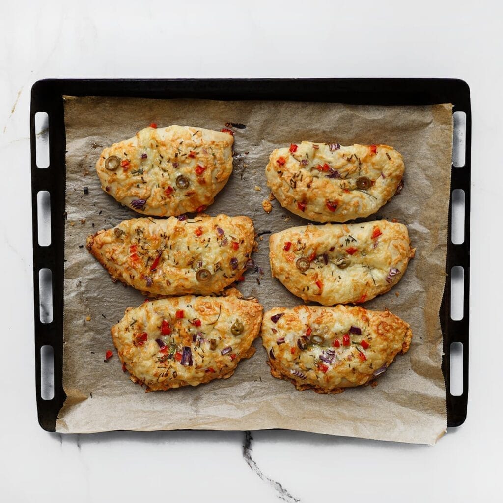 Bak de pizzabroodjes in een voorverwarmde oven op 200 &deg;C in 12-18 minuten goudbruin. 