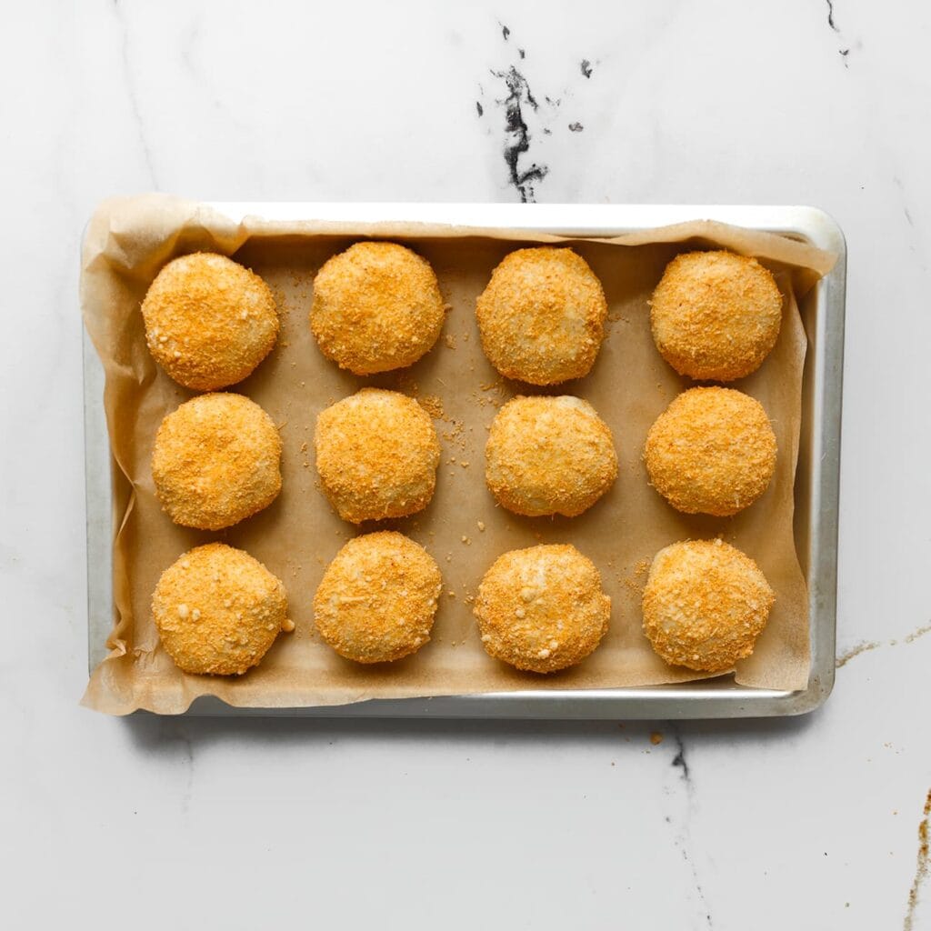 Leg de broodjes op een met bakpapier beklede bakplaat. Laat ze 30 minuten rijzen op een warme plek.