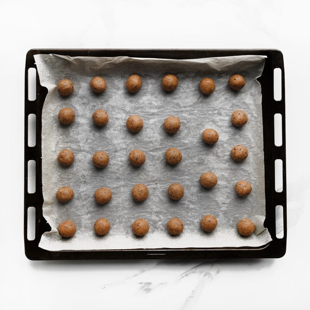 Neem 14 gram van het koekjesdeeg en vorm er een bol van. Leg de bollen op een met bakpapier beklede bakplaat.