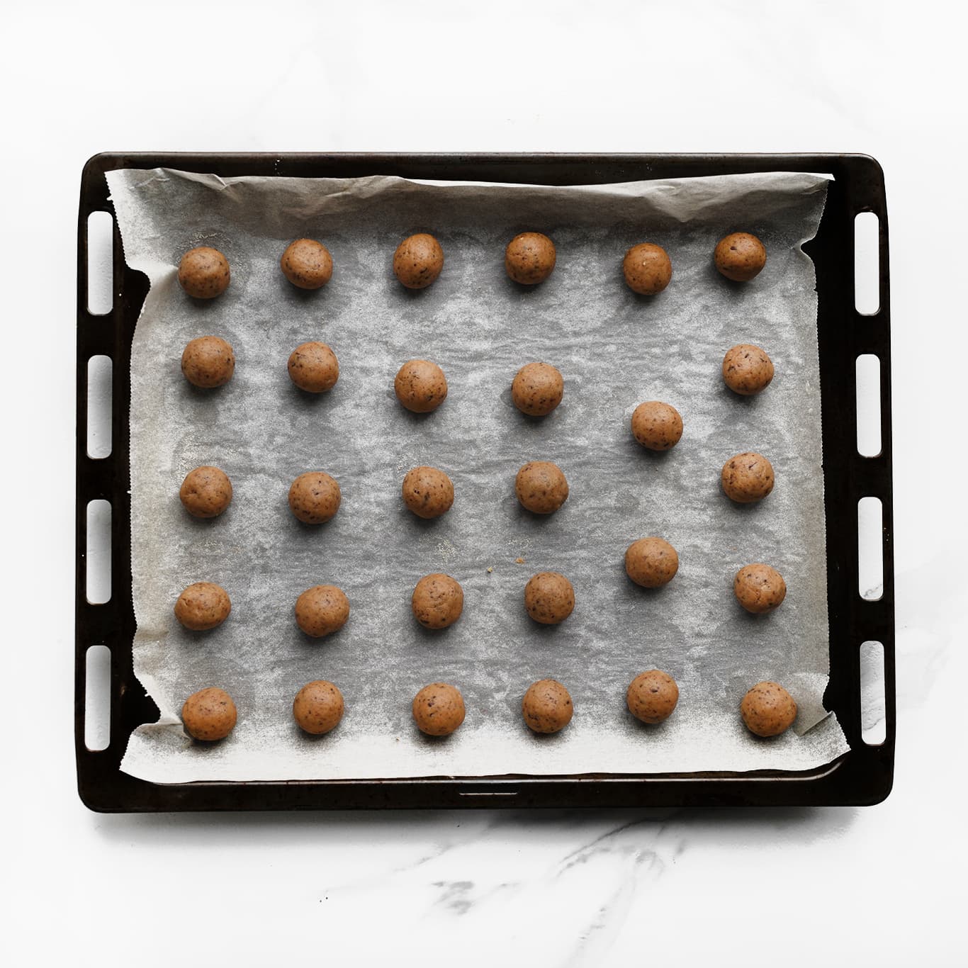 Koekjesdeeg op bakplaat met bakpapier leggen