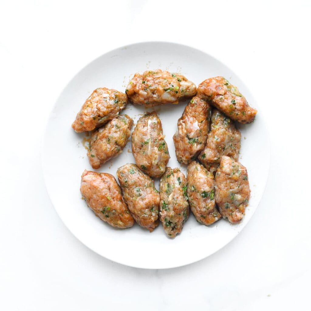 Neem porties van het gehaktmengsel en vorm er bollen van. Druk ze licht plat.