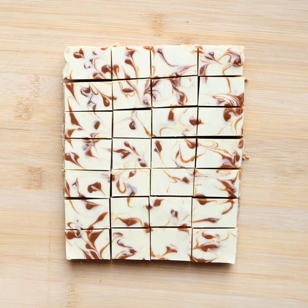 Snijd de stroopwafelkoek in vierkante blokjes en serveer.