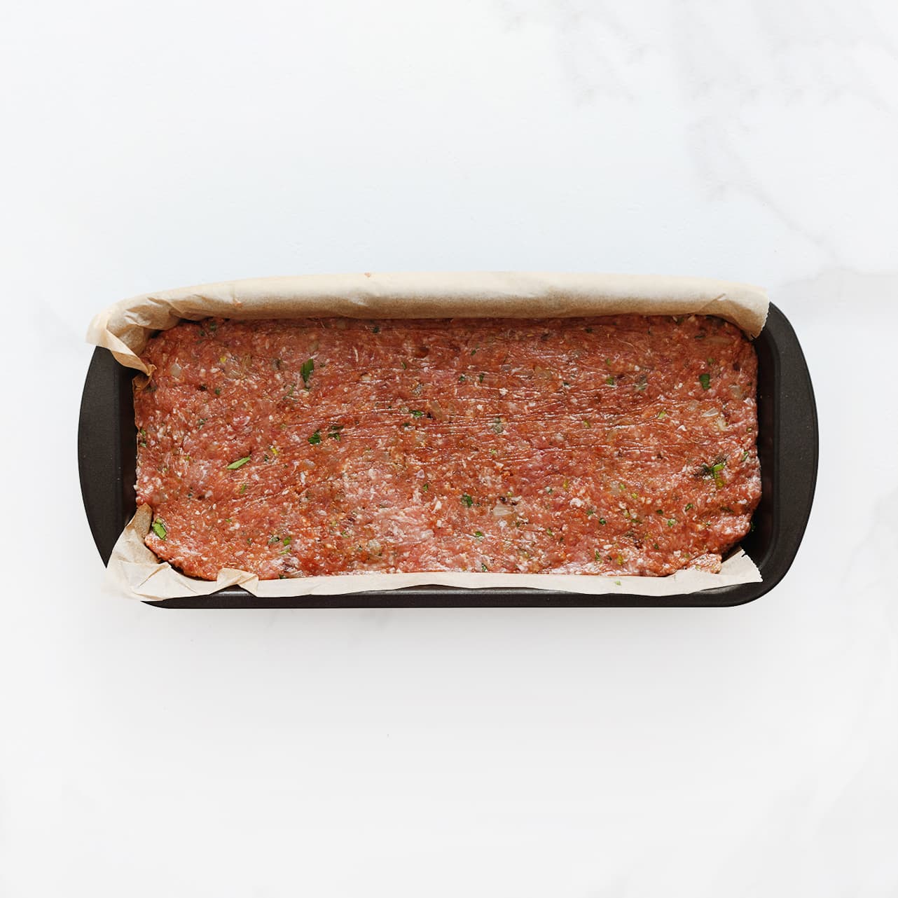 Meatloaf over de bakvorm verdelen