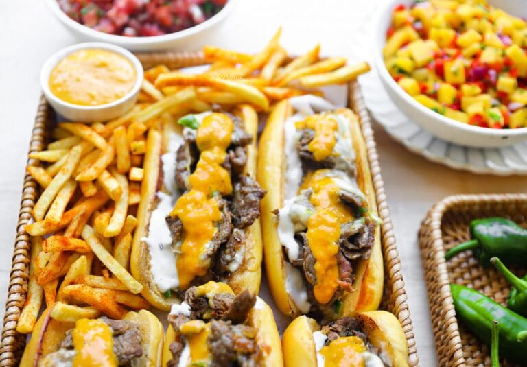 Philly cheesesteak broodjes gevuld met dungesneden ribeye, gesmolten Goudse kaas, jalapeño en cheddar saus