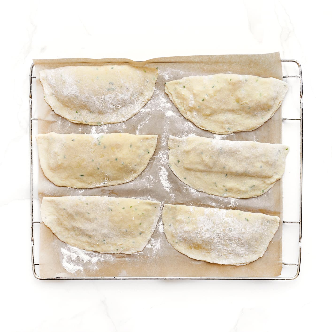 Platte kaasbroodjes op bakpapier leggen