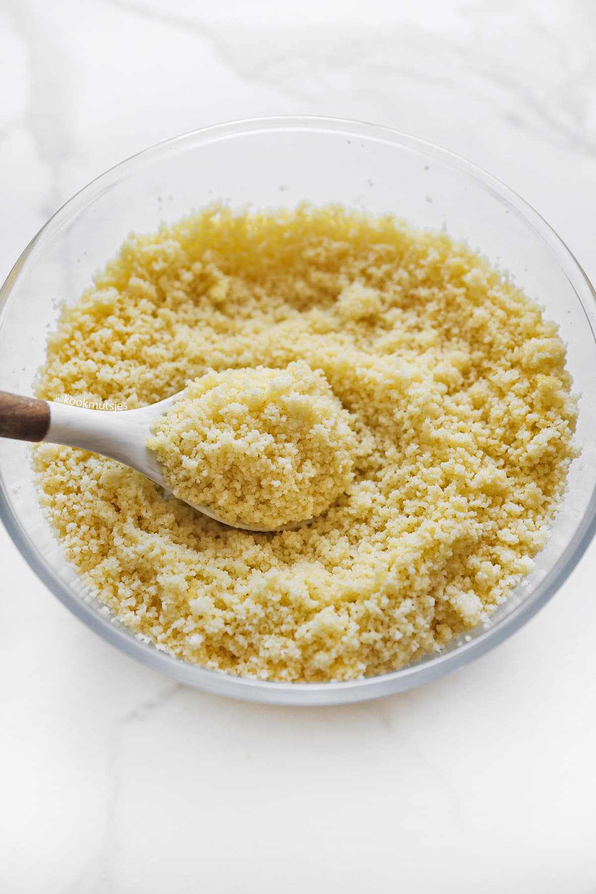 Couscous die wordt losgemaakt en gestoomd in een couscouspan tijdens de bereiding