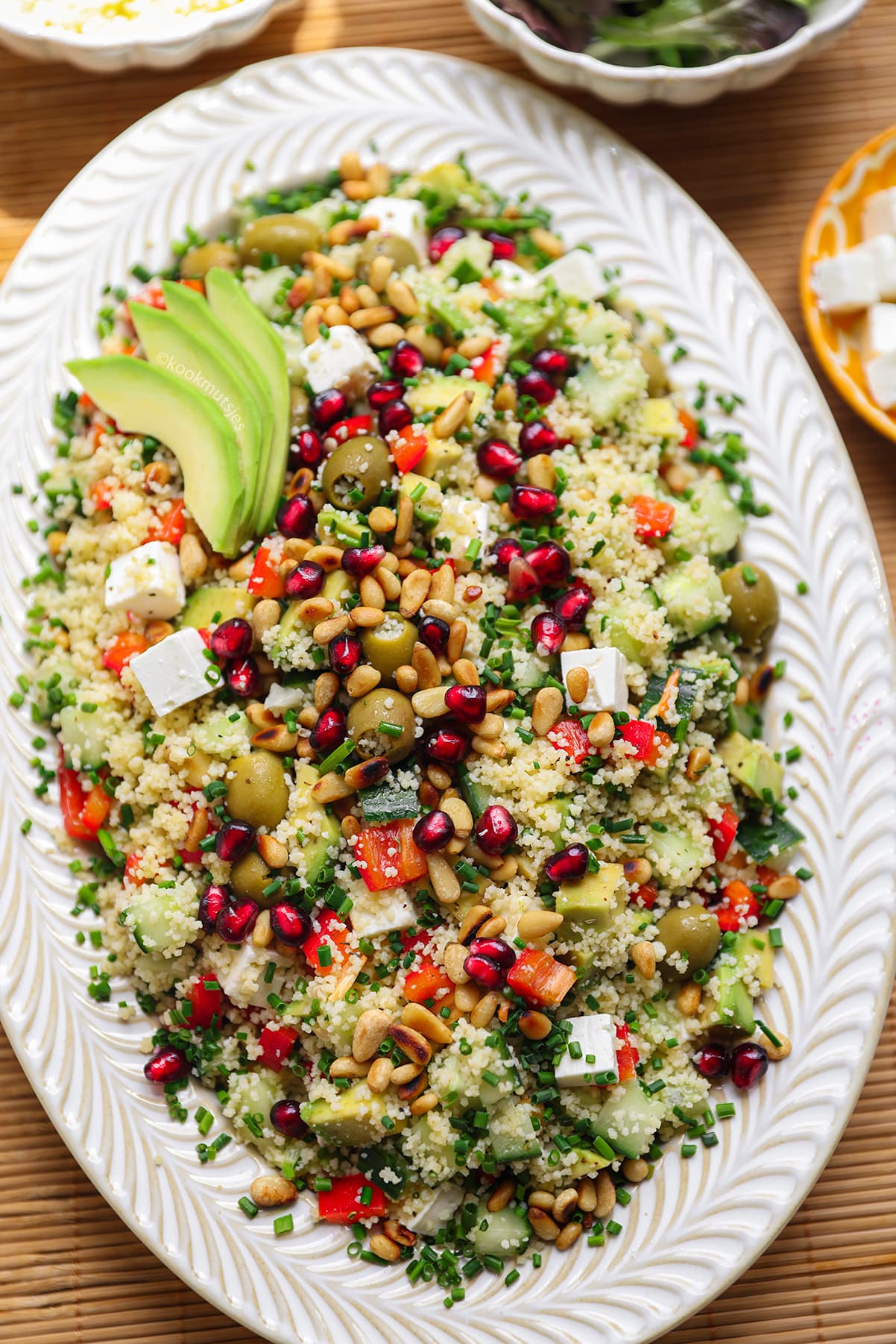 Close-up van mediterrane couscoussalade met feta, avocado, olijven en granaatappelpitjes