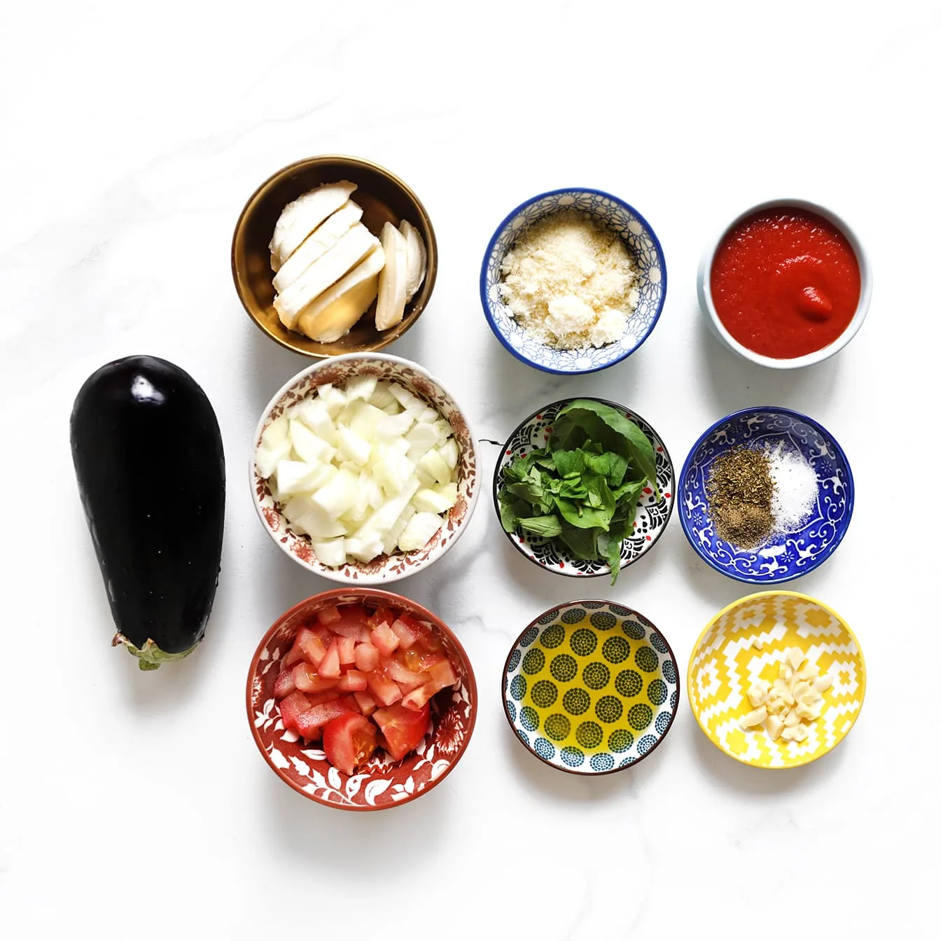 Ingrediënten voor melanzane alla parmigiana met aubergine, tomatensaus, mozzarella en Parmezaanse kaas