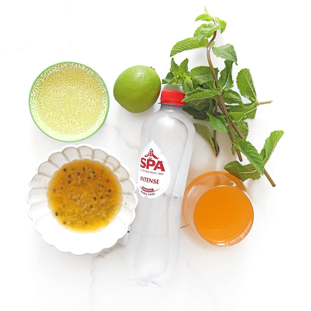 Ingrediënten voor een passievrucht mojito mocktail met passievrucht, munt, limoen, citroensiroop en Spa Rood.