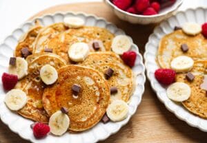 Stapel luchtige bananen pannenkoeken met chocolade chunks op een bord
