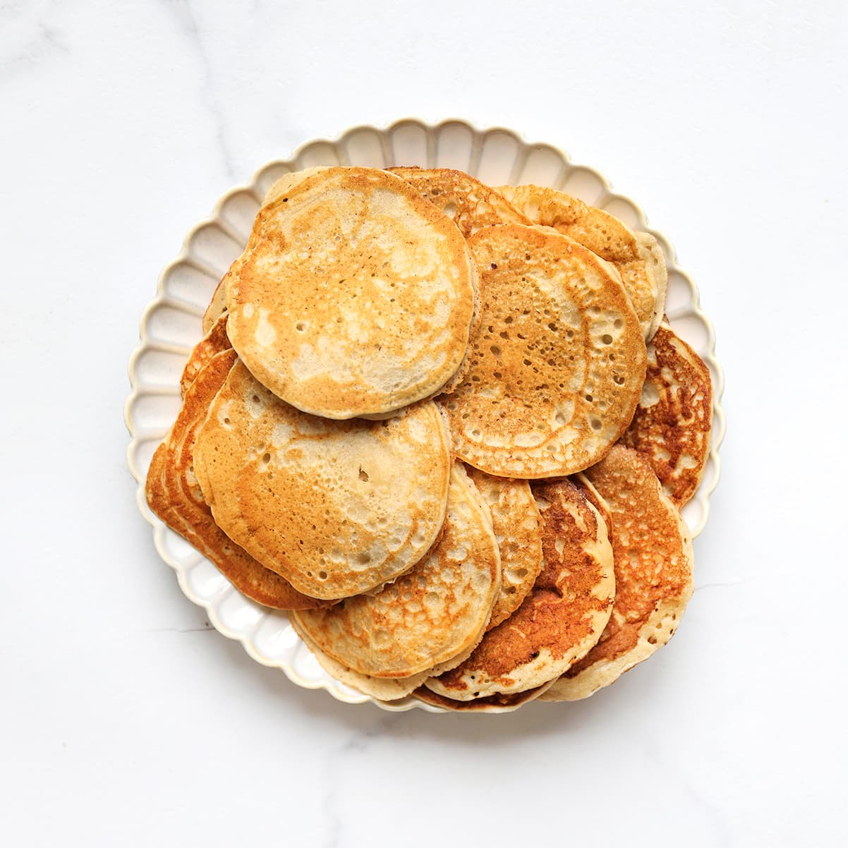 Goudbruine bananenpannenkoekjes worden omgedraaid in de koekenpan