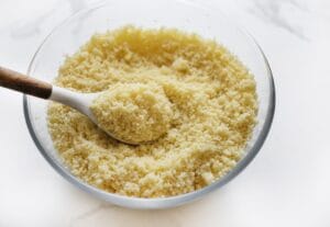 Luchtige gestoomde couscous bereiden in een schaal, bereid volgens traditioneel Marokkaans recept