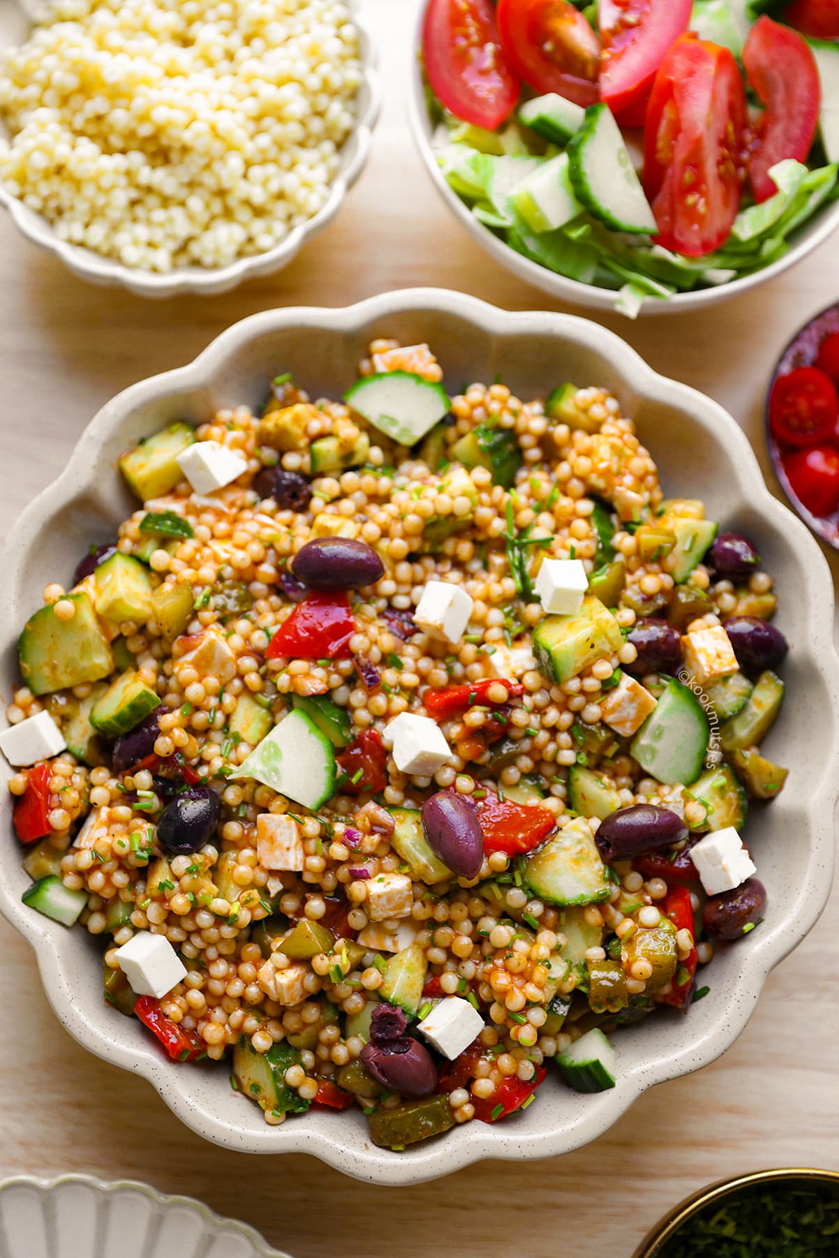 Mediterrane parelcouscoussalade met feta, avocado, groenten en kalamata olijven.